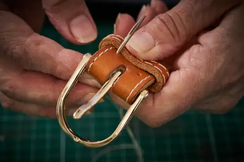 Magali Billy Maroquinerie artisanale en Vendée, Pays de la Loire, France. Finition ceinture en cuir, tannage végétal, avec des points main, dans son atelier.
