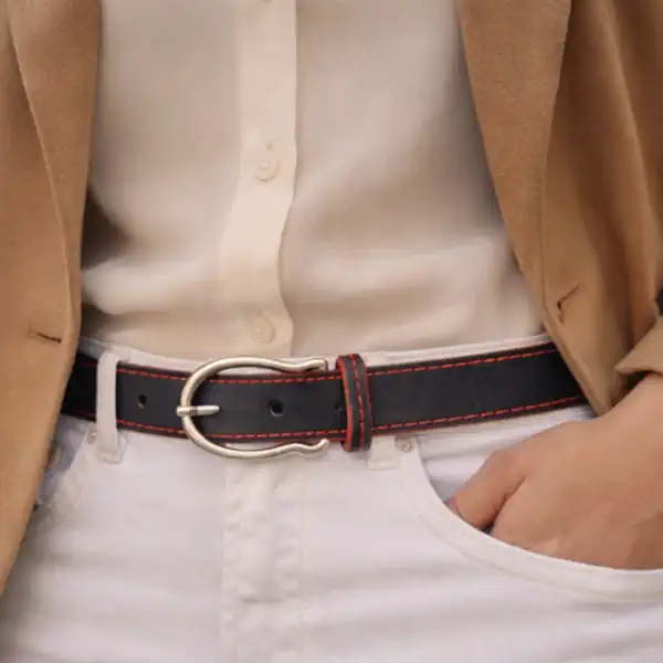 Ceinture en cuir noir, teintée rouge vif, avec piqure décorative rouge. Fabrication artisanale dans notre atelier en Vendée, France. Portée.