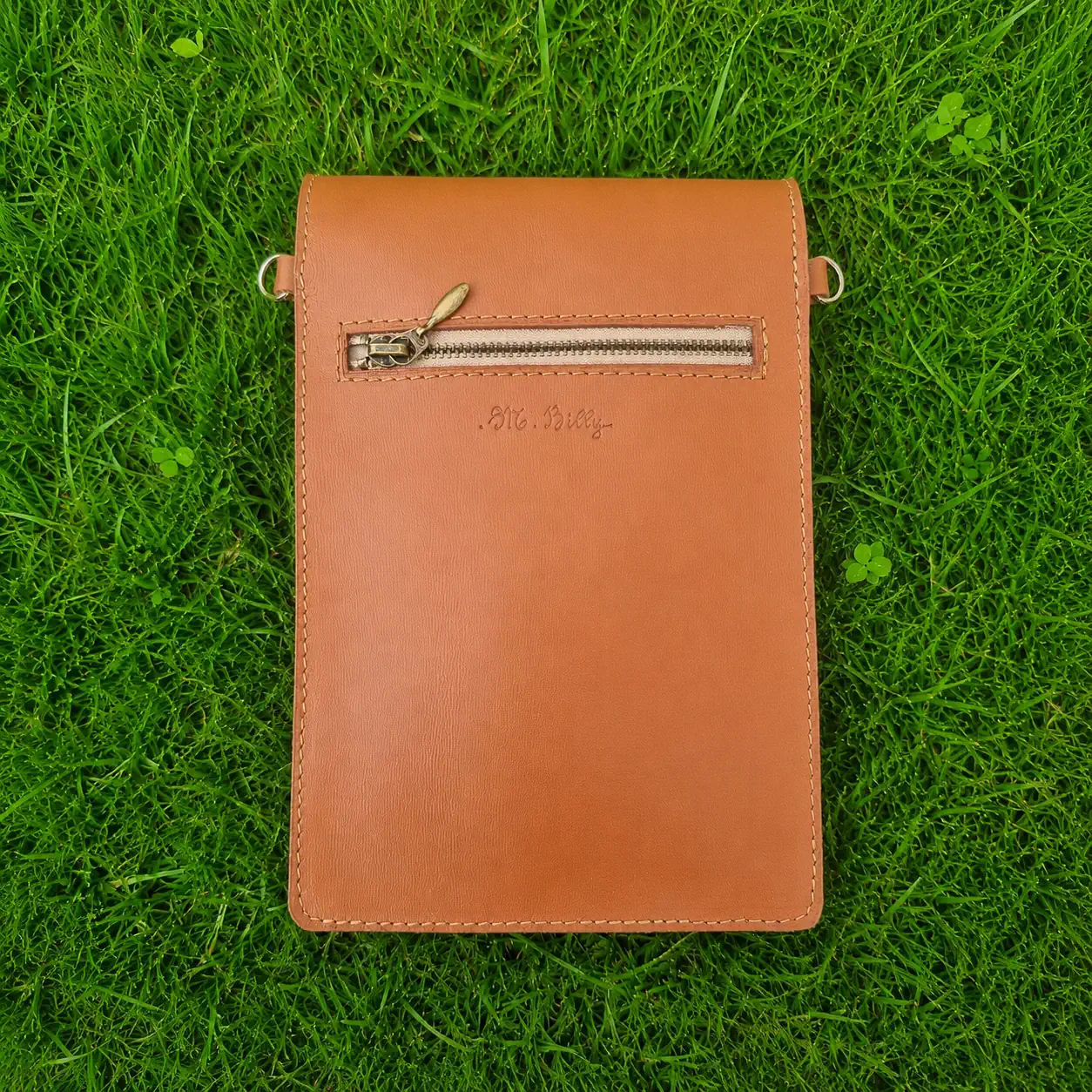 Pochette artisanale en cuir camel et beige à motifs jungle, portée en bandoulière. (Dos)