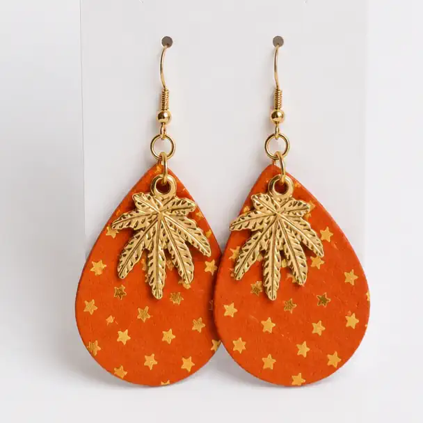 Boucles d'oreilles artisanales en cuir orange décoré de petites étoiles dorées avec feuille de cannabis métallique dorée en.
