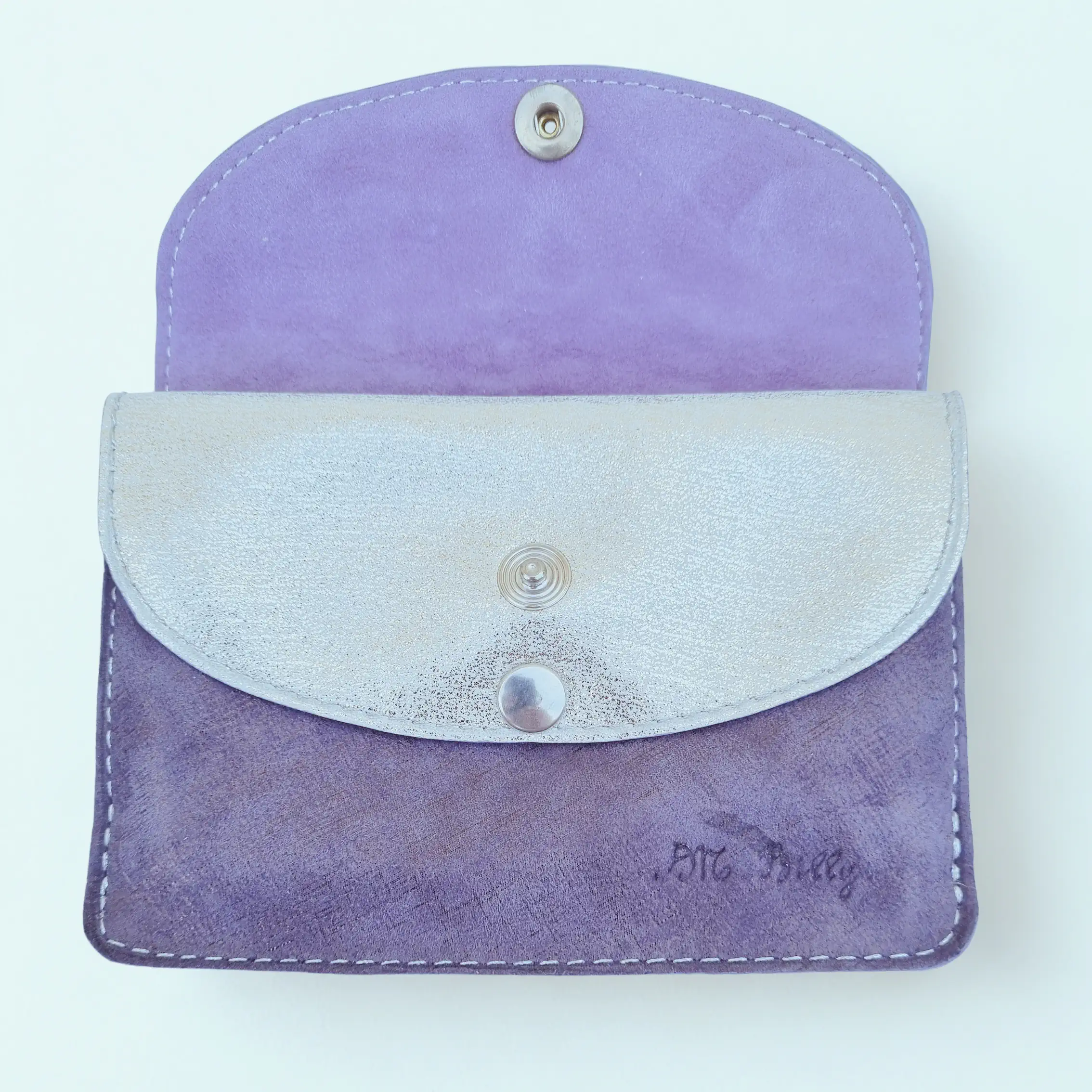 Portefeuille femme en cuir à rabats format moyen. Rabat intérieur argenté métallisé et cuir de chèvre violet. Vue intérieure de face.